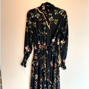 High-low dress silhouette to enhanced the flow. Smocked high neck ruffle wrist.